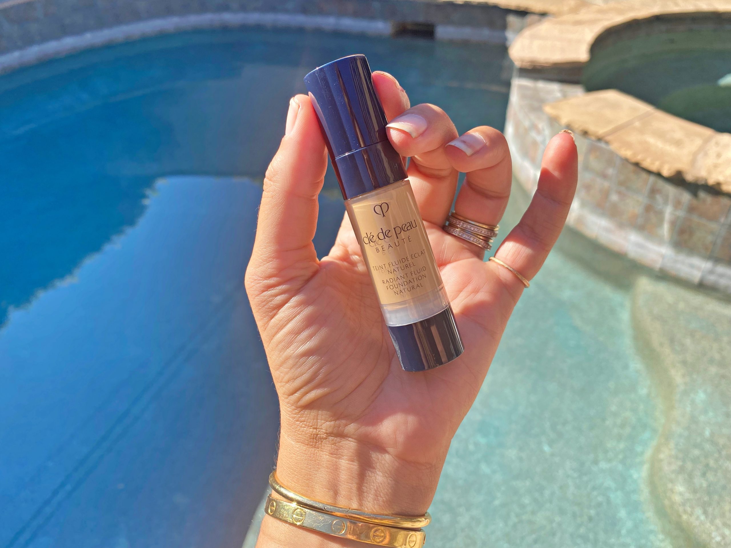 woman holdign the cle de peau radiant fluid foundation natural swatches