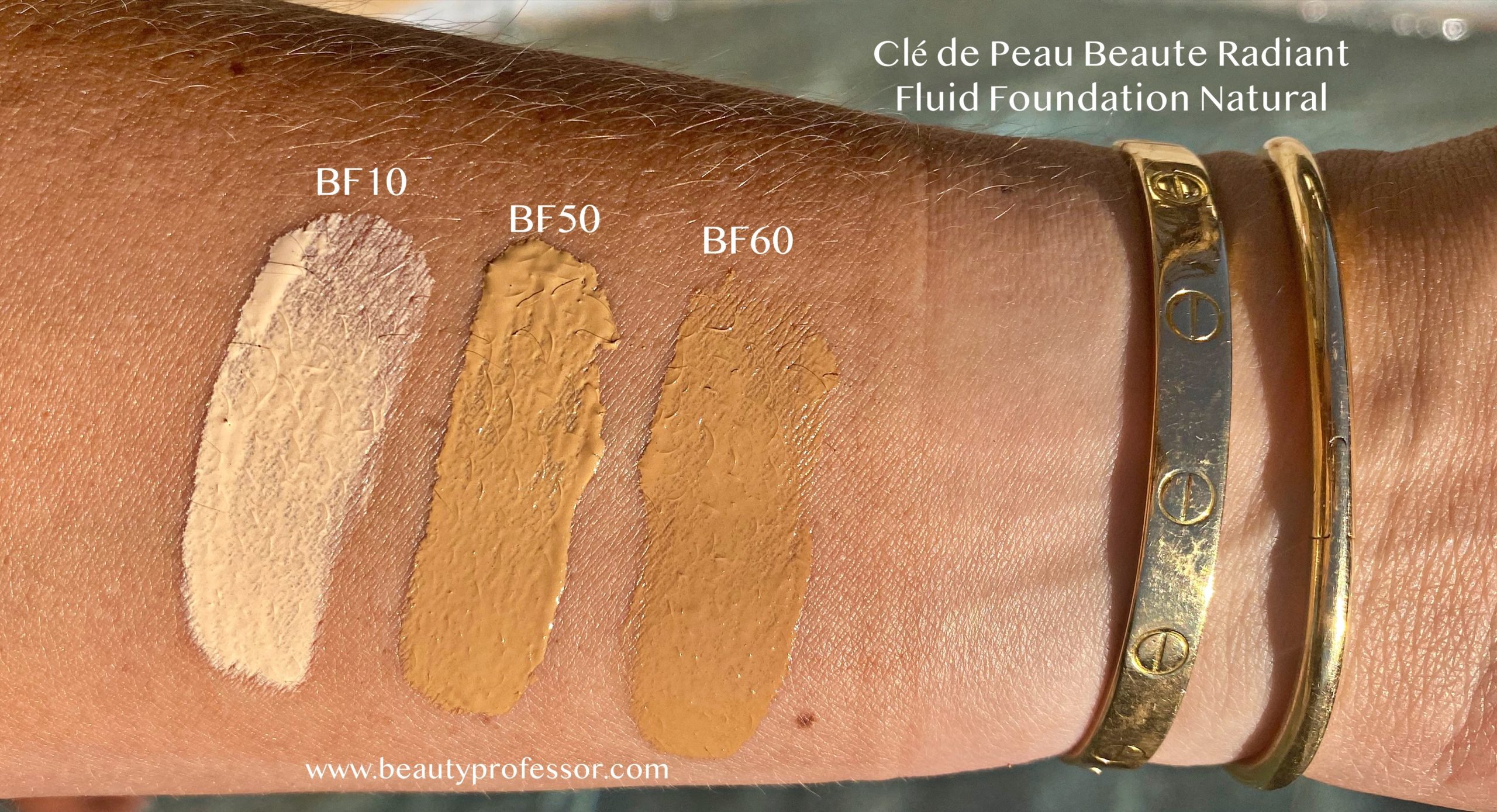 three cle de peau radiant fluid foundation natural swatches on an arm